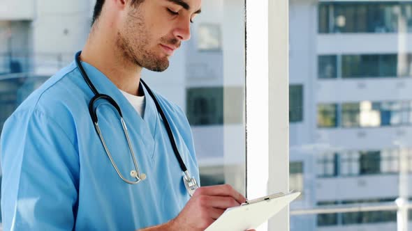 Portrait of male doctor writing on a clipboard