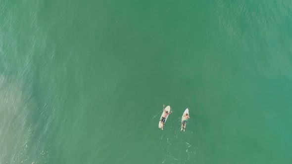 Surfers On Boards Waiting For A Wave