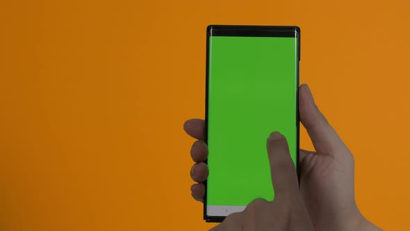 Smartphone screen. Smart phone isolated on color background. Green screen chroma key technique. Man