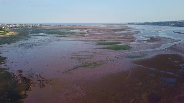 Aerial view of the town and beach life in Lympstone, a coastal town in England. Water plants are vis