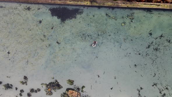 Aerial view of woman swimming in Glencairn pool, Cape Town, South Africa.