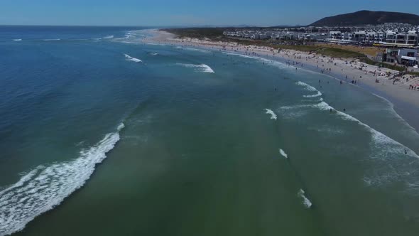 Drone shot of Blouberg beach in Cape Town - drone is flying over Big Bay surfers beach. Snippet coul