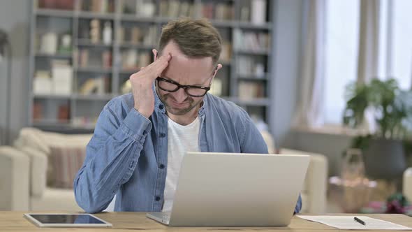 Tired Young Man Having Headache in Loft Office 