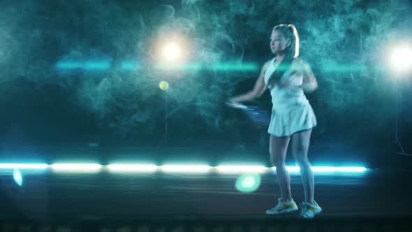 Athletic Lady is Playing Tennis in a Dark Hall