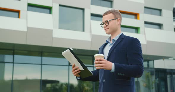 The Businessman Is Looking Through the Documents in the Folder