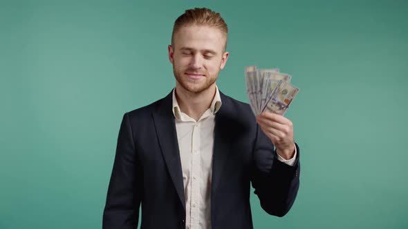 Amazed Happy Excited Business Man with Cash Money  USD Currency Dollars Banknotes on Green Wall