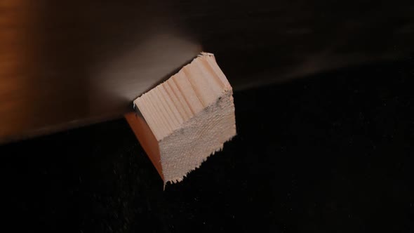 Man Carpenter Saws a Wooden Board with a Hand Saw