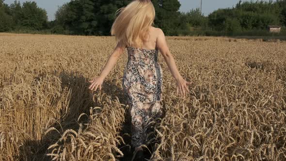 Young girl running across the field at sunset. Slow motion