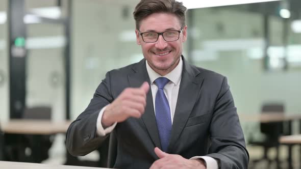 Positive Middle Aged Businessman Doing Thumbs Up