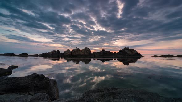 Colorful sunrise sky at rocky coastline 