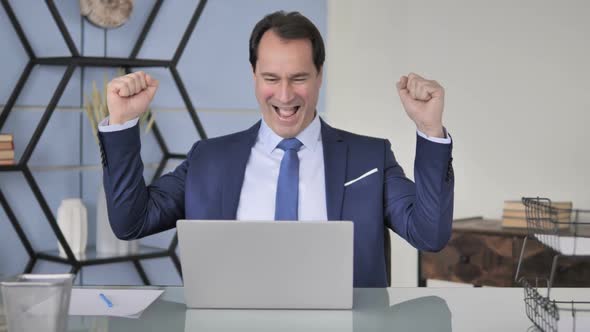 Excited Businessman Celebrating Success at Work