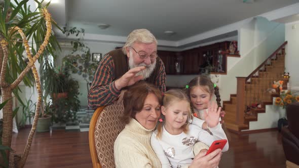 Mature Couple with Their Grandkids Talking By Cell Phone Using Camera