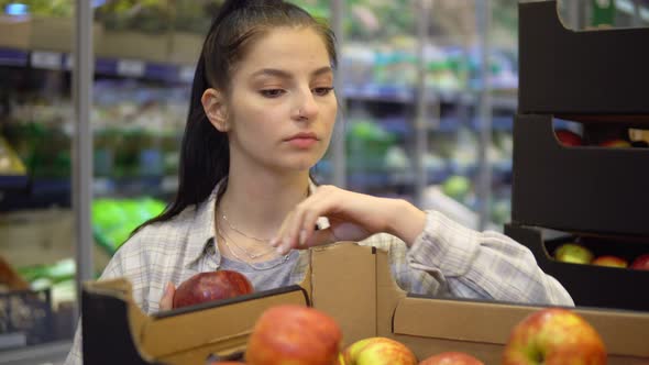 Woman Choosing Apples in Supermarket