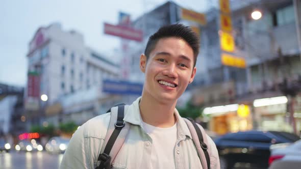 Asian attractive man backpacker walking around the city at night road.