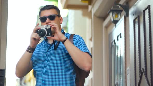 Young man taking photo on camera of city scape. Concept of solo travelling