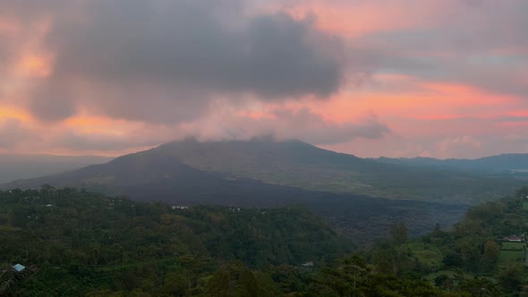 A Timelapse with a Volcano and Clouds That Spin Around Its Top at Sunset