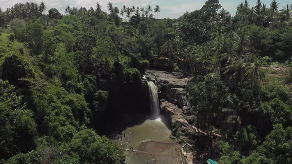 aerial view of powerful waterfall in the island of Bali in Indonesia surrounded by green vegetation