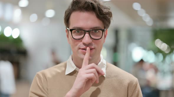 Attractive Young Male Designer Showing Quiet Sign Finger on Lips