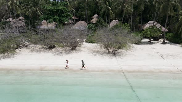 A Drone Shot of Happy Couple on Romantic Honeymoon Vacation Sunset Watching Running of Happiness on