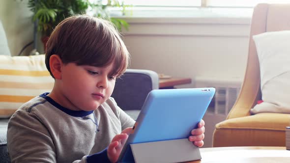 Boy using digital tablet in living room 4k