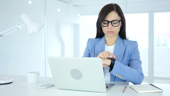 Woman Using Smartwatch at Work in Office