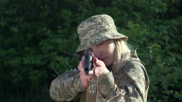 Closeup Woman in Uniform in Zone of Armed Conflict Aims with an Assault Rifle