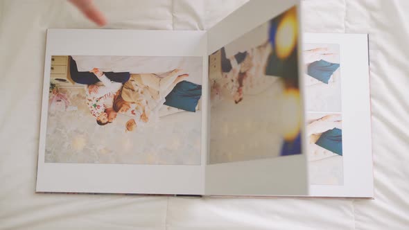 Hands Scroll Through Pages of Photobook on White Background