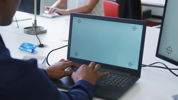 Hands of mixed race businessman using laptop at desk in office