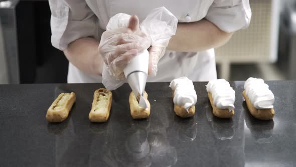 Decorating Eclairs with Cream. Using Cooking Bag, Confectioner Making Eclairs