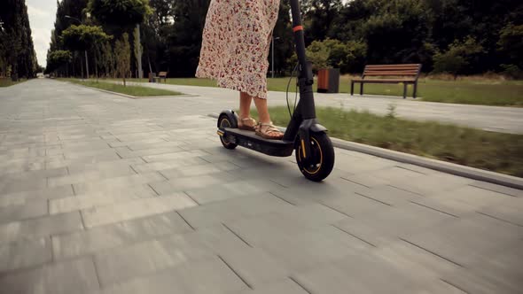 Woman Ride On Electric Scooter Mobility.E-Scooter Rider Rent Personal Eco Transport. Driving Ecology