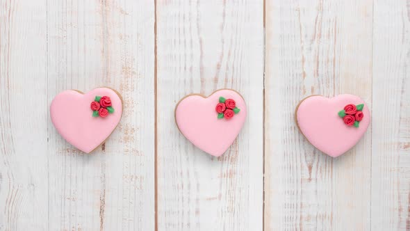 heart shaped ginger cookies with red glazed roses rotating close-up