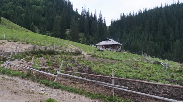 Panoramic View of an Old Wooden Building on Hill in Mountains at the Countryside