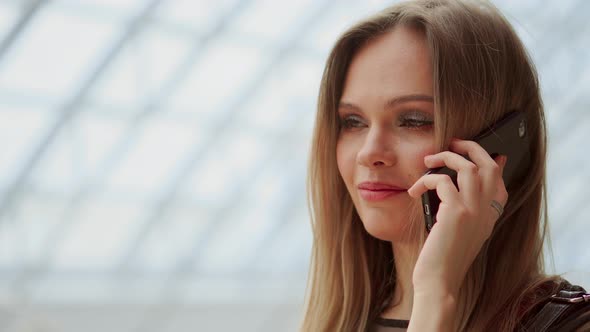 Young Attractive Girl Goes Shopping in Mall, Talking on Phone, Shopping Concept, Fashion Concept