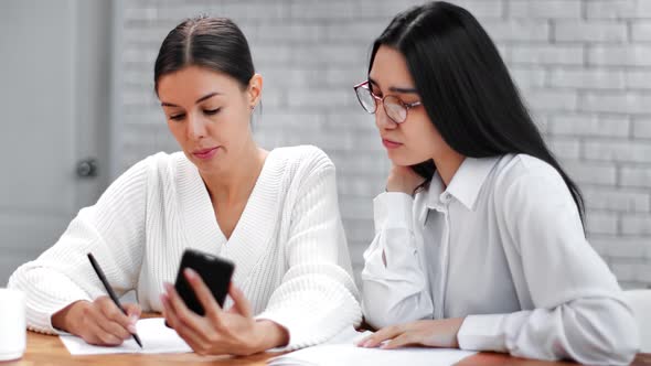 Female Colleagues Having Meeting Communicating Making Notes