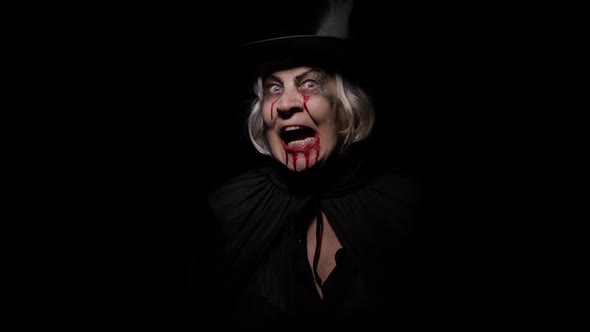 Old Witch Halloween Makeup. Elderly Woman Portrait with Blood on Her Face.