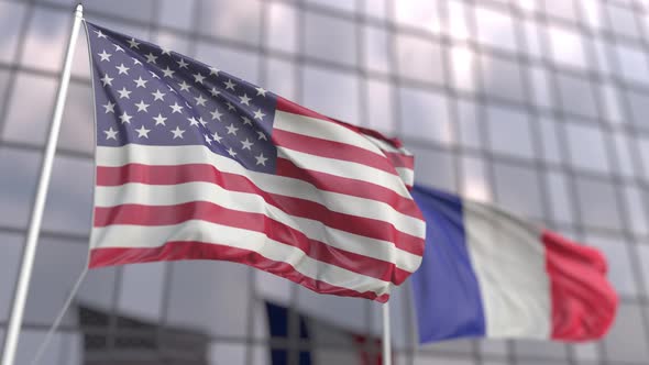 Waving Flags of the USA and France in Front of a Skyscraper
