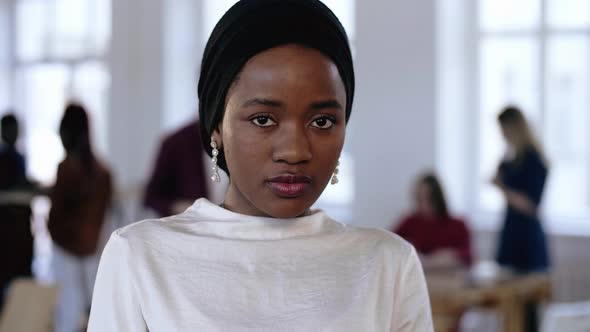 Young Serious African Business Manager Woman in Ethnic Turban Looking at Camera, Smiling at Modern