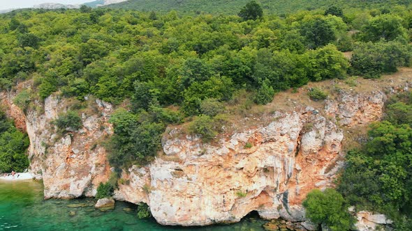 Aerial (drone) truck shot from right to left of Macedonian shore in Ohrid Lake, Pesztani and Trpejca