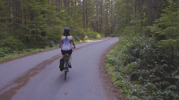 Adventurous Woman Bike Riding on a Trail in Forest