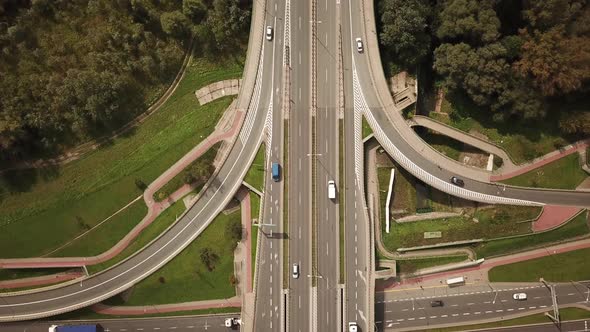 Aerial high drone flight over evening road traffic. Highway and overpass with cars and trucks, inter