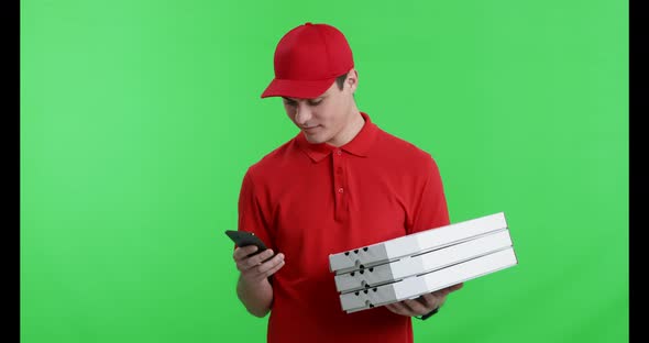 Young Courier with Pizza Noting Order on Phone