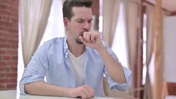 Sick Young Man Having Coughing in Modern Office