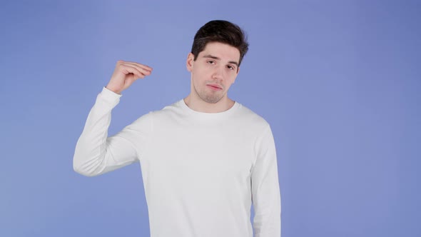 Handsome Bored Man Showing Blablabla Gesture with Hands and Rolling Eyes Isolated on Violet