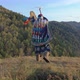 Energetic Dance of an Old Shaman with a Tambourine on the Background of Autumn Mountain Landscape - VideoHive Item for Sale