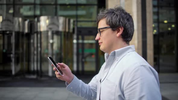 Portrait Profile Shot of Man in Eyeglasses and Blue Shirt Walking Along the Street