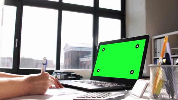 Woman with Laptop and Papers Working at Home