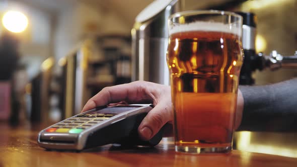 Buying Beer and Paying By Smartphone Closeup