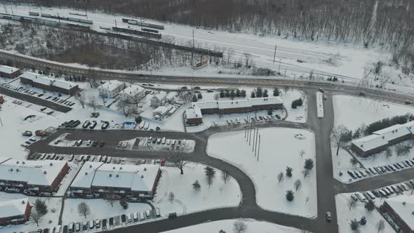 Small town neighborhood, trees covered with snow, homes in white, aerial drone view.