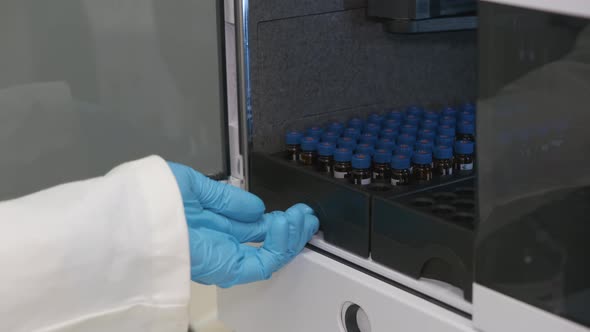 Analytical Chemist Puts a Vials To Auto Sampler of HPLC System. Development Pharmaceuticals and