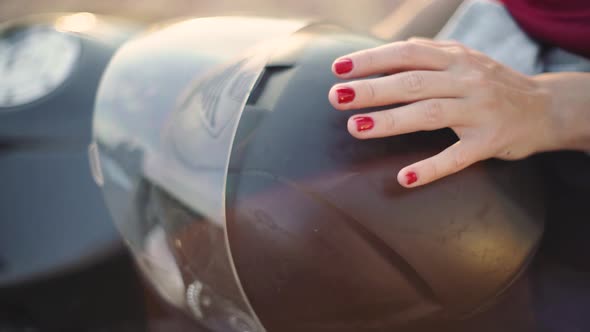 Beautiful Young Redhaired Woman Motorcyclist with Her Motorcycle and Helmet